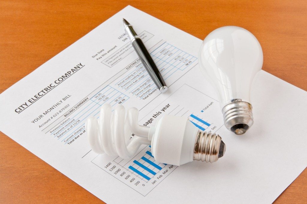 Electricity bill with light bulb and pen on top