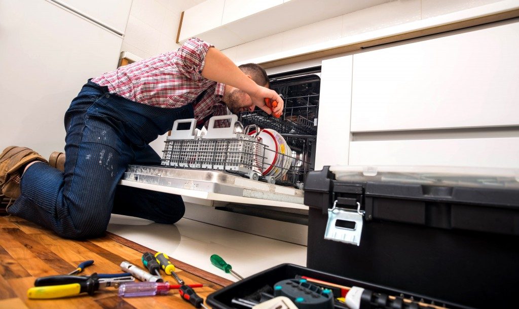 Handyman fixing the dishwasher