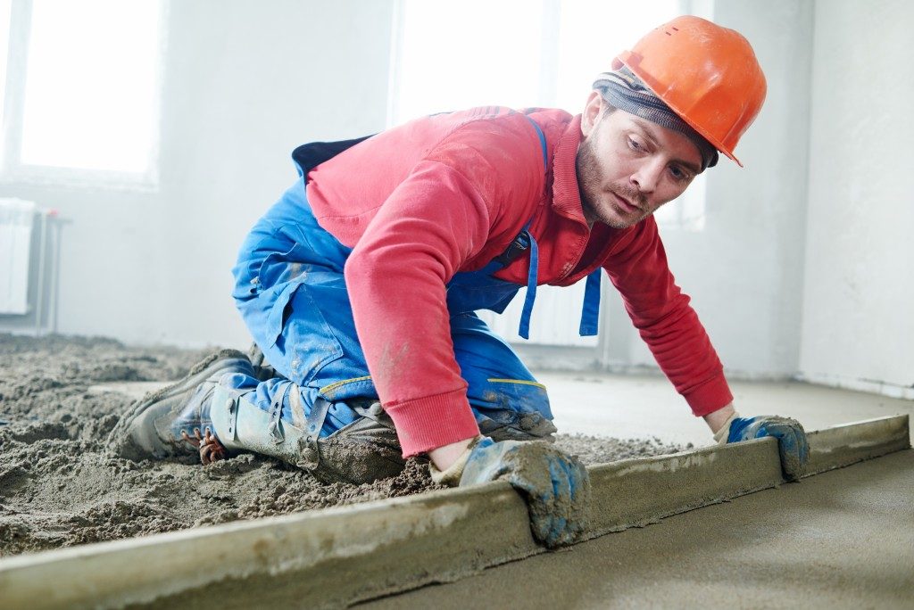 man constructing concrete flooring