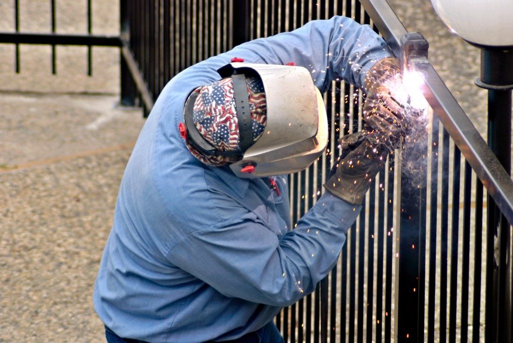 worker installing a metal fence