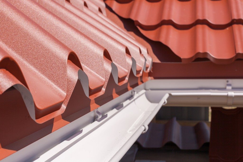 roof in red metal tile with white rain gutter