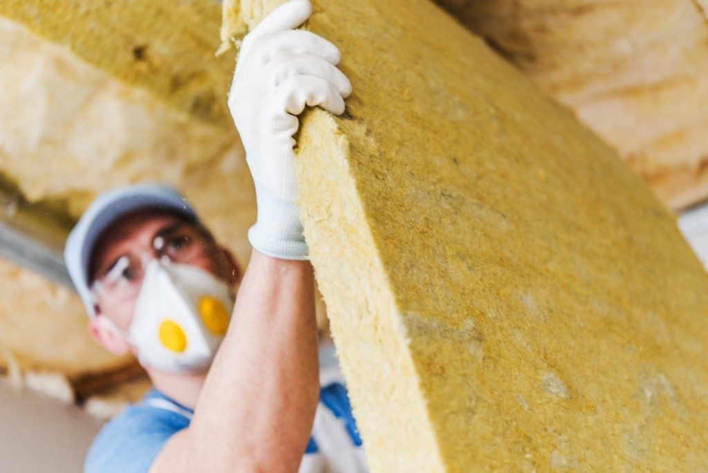 Worker insulating a house