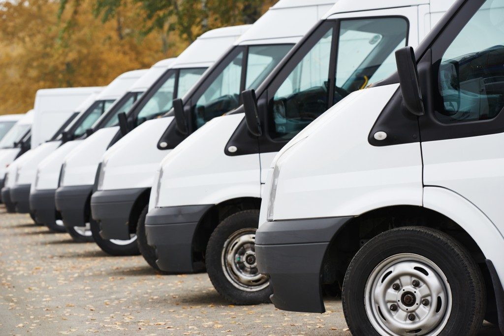 commercial delivery vans in row at parking place of transporting carrier shipping service company