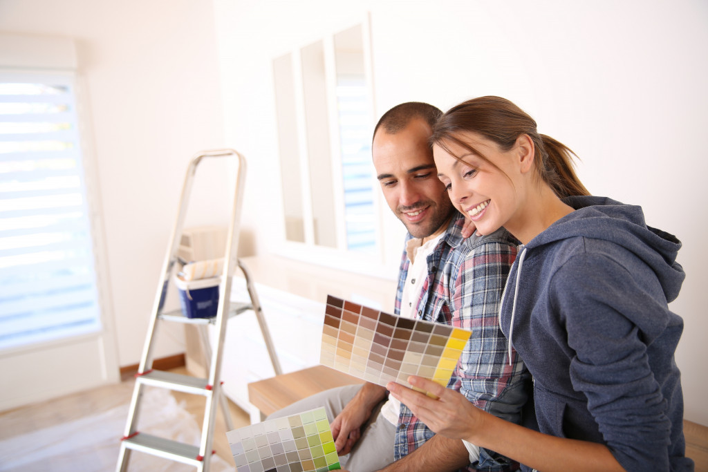 man and woman holding paint palette choosing color